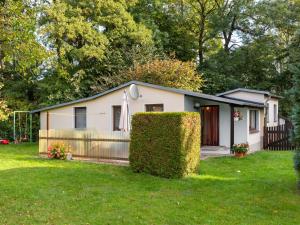 uma pequena casa branca com uma cerca e um quintal em Beautiful Holiday House In Biendorf with Garden em Körchow