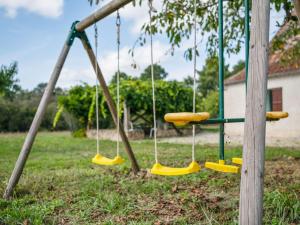 a swing in a park with yellow swings at Holiday home in Cendrieux with garden shed in Cendrieux