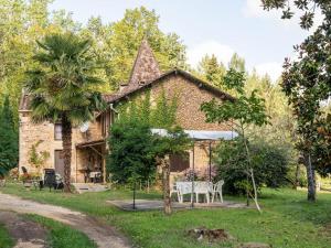 a brick house with a table and chairs in the yard at Cosy holiday home with garden in Villefranche-du-Périgord
