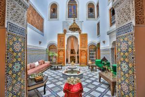 uma sala de estar com um sofá e uma mesa em RIAD CHAHD PALACE em Fez