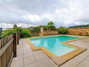 a swimming pool in a yard with a stone wall at Vintage Holiday Home in Loubejac with a Private Pool in Villefranche-du-Périgord