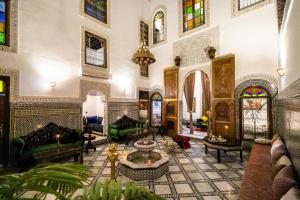 a living room filled with furniture and stained glass windows at RIAD CHAHD PALACE in Fez