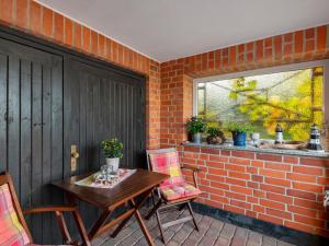 a patio with a table and chairs and a brick wall at Central Apartment, Bad Doberan in Bad Doberan