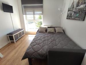 a small bedroom with a bed and a window at ALCAZABA ELITE in Sierra Nevada