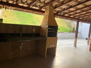 an outdoor kitchen with a brick oven in a house at Casa temporada centro capitolio MG in Capitólio