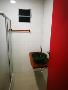 ein Bad mit einem grünen Waschbecken und einem Fenster in der Unterkunft Zen Spa Houses in São Miguel dos Milagres