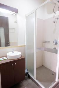 a bathroom with a glass shower and a sink at Rumah Kamang Residence in Jakarta +32 photos