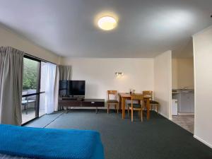 a living room with a table and a dining room at Pembrooke Motor Lodge in Whangarei