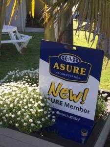 a new service member sign sitting in a bed of flowers at Pembrooke Motor Lodge in Whangarei