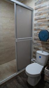 a bathroom with a toilet with a sliding shower door at Rocky Cay Lodging in San Andrés
