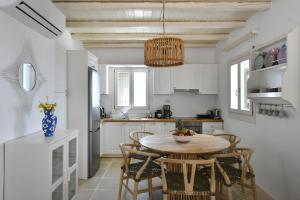 a kitchen with a table and chairs in a room at Luxury Paros Villa Villa Aethra Beautiful Serene Glisidia in Kampos Paros