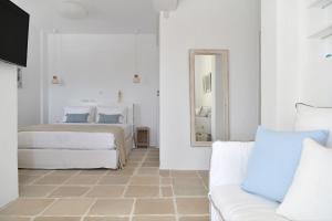 a bedroom with two beds and a mirror and a couch at Luxury Paros Villa Villa Aethra Beautiful Serene Glisidia in Kampos Paros