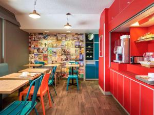 hotelF1 Moret Fontainebleau في موريه-سور-لوينغ: مطعم به طاولات وكراسي وجدران حمراء