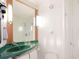 a bathroom with a green sink and a toilet at ibis Hotel München Garching in Garching bei München