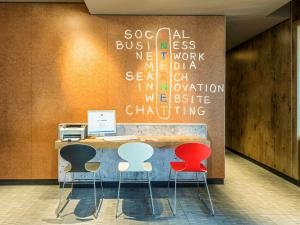 an office with a desk with four chairs and a computer at ibis Hotel München Garching in Garching bei München