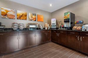 une cuisine avec des placards en bois et un bar-café dans l'établissement Comfort Inn & Suites Butler, à Butler