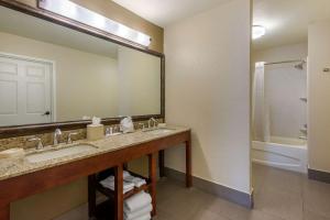 群村的住宿－村落康福特套房酒店，浴室配有盥洗盆、镜子和浴缸