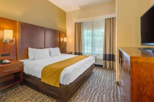 a hotel room with a large bed and a television at Comfort Suites The Villages in The Villages