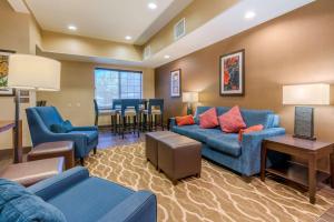 Comfort Inn & Suites Galt – Lodi North في Galt: غرفة معيشة مع أرائك زرقاء وغرفة طعام