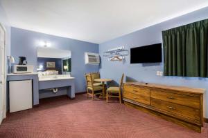 a room with a desk and a kitchen with a sink at Rodeway Inn & Suites Blythe I-10 in Blythe