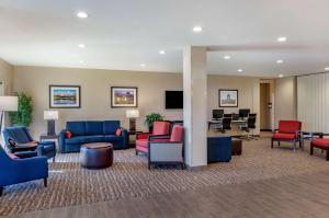 een lobby met blauwe en rode stoelen en bureaus bij Comfort Suites Helena Airport in Helena