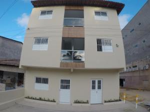 un edificio blanco con ventanas y puertas en Flats Recanto do Sol, en Maragogi
