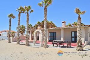 a house on the beach with palm trees at Casa Chapman by FMI Rentals in Puerto Peñasco