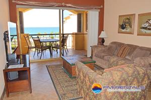 a living room with a couch and a view of the ocean at Princesa C - 402 by FMI Rentals in Puerto Peñasco