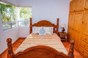 1 dormitorio con cama de madera y ventana en Casa del Sol by FMI Rentals en Puerto Peñasco