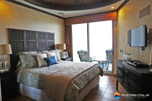 a bedroom with a large bed and a television at Esmeralda #803 by FMI Rentals in Puerto Peñasco