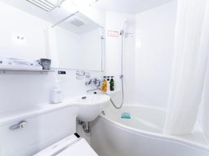 大阪的住宿－APA Hotel SHIN-OSAKA MINAMIKATA EKIMAE，白色的浴室设有水槽和淋浴。