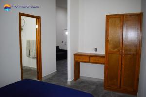 1 dormitorio con armario de madera y espejo en Turtle Studio en Puerto Peñasco