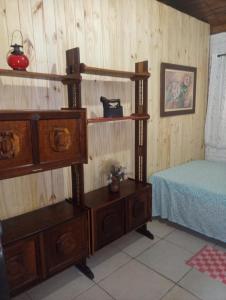 ein Schlafzimmer mit einem Bett und einer Holzwand in der Unterkunft Rancho Pedra Preta in Itamonte
