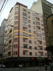 un edificio con un círculo amarillo a su lado en 123m Apartamento Centro de Curitiba, en Curitiba