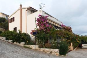 a building with flowers on the side of it at Apartments Zeljko - with garden in Seget Vranjica