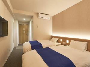 a hotel room with two beds and a television at Hotel Meriken Port Kobe Motomachi in Kobe