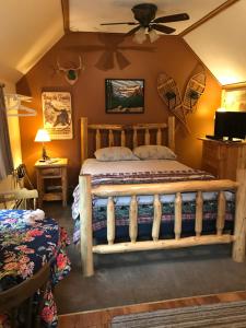 1 dormitorio con 1 cama y ventilador de techo en Holiday Lodge Cabins en Banff