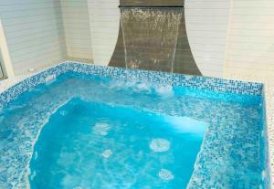 una piscina azul con cascada en una casa en Hospedaje Las Tres Regiones, en Lima