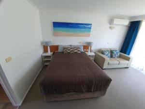 a bedroom with a bed and a desk at Town Beach Motor Inn Port Macquarie in Port Macquarie