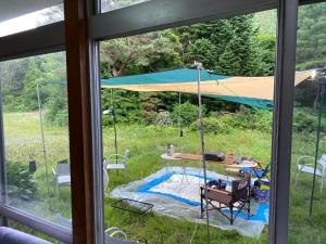 Una ventana con vistas a una tienda de campaña en Towadako Hostel en Towada