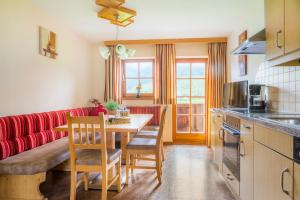 a kitchen with a table and a red couch at Matzhof in Leogang