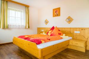 a bedroom with a wooden bed with orange sheets at Matzhof in Leogang