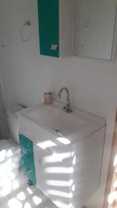 a white sink in a bathroom with a green cabinet at LA Jolla Suítes Alto da Lapa in Sao Paulo +38 photos