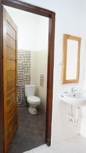 a bathroom with a toilet and a sink at Jingga Homestay Balangan in Jimbaran