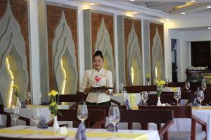 a man holding a plate of food in a restaurant at Khmer Mansion Residence in Siem Reap