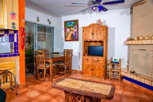 sala de estar con TV, mesa y sillas en La Felicidad, en Puerto Peñasco