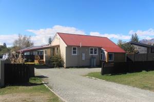 a house with a red roof and a fence at Le Refuge in Lake Tekapo