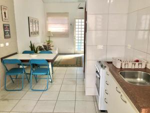 皮拉西卡巴Casa com ótima localização的厨房配有水槽和一张带蓝色椅子的桌子