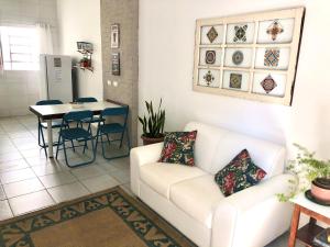uma sala de estar com um sofá branco e uma mesa em Casa com ótima localização em Piracicaba