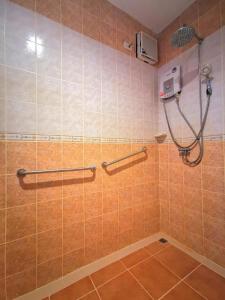 um chuveiro na casa de banho com azulejos laranja em Aumpai Luxury em Lamai